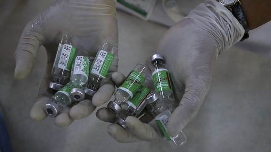 A health worker displays empty vials of the Covishield vaccine during a special vaccination drive in Hyderabad on June 21. The government is expecting to get around 200-250 million doses per month by August as vaccine manufacturers such as Serum Institute of India and Bharat Biotech are in the process of scaling up their vaccine production capacity, HT reported.(Mahesh Kumar A / AP)