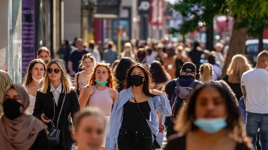 Pedestrians, some wearing face coverings due to Covid-19, walk past shops on Oxford Street in central London on June 7, 2021. (AFP)