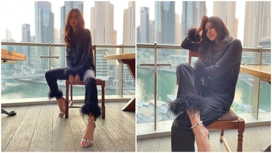 Loungewear is not just an attire to be worn at home. You can always give it a chic twist and wear it for an outing, and here, Mouni Roy shows how. She opted for a satin silk shirt and pants adorned with feathers on the cuffs and hem.(Instagram/@imouniroy)
