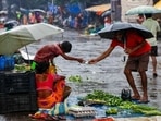 A man buy vegetables from a roadside vendor at a marketplace during monsoon rains. A man buy vegetables from a roadside vendor at a marketplace during monsoon rains.