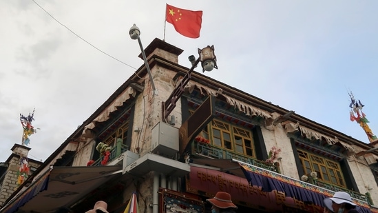 A Chinese flag flutters above surveillance cameras in Lhasa, Tibet.(Reuters)