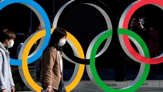 File Photo: Women wearing protective face masks following an outbreak of the coronavirus disease (COVID-19) walk past the Olympic rings in front of the Japan Olympics Museum. (REUTERS)