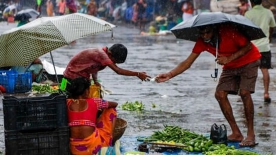 A man buy vegetables from a roadside vendor at a marketplace during monsoon rains. (AP representative image)