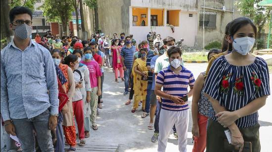 Beneficiaries wait in a queue to receive a dose of Covid vaccine at a vaccination centre in Jammu on Wednesday. (PTI)