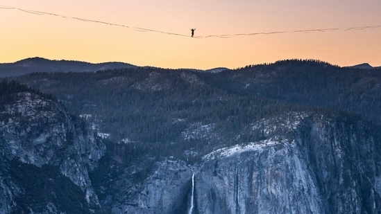 In this Saturday, June 12, 2021, photo provided by Scott Oller Films, highliner Daniel Monterrubio walks the 2,800-foot-long line off Taft Point above Yosemite Valley in Yosemite, Calif. (AP) In this Saturday, June 12, 2021, photo provided by Scott Oller Films, highliner Daniel Monterrubio walks the 2,800-foot-long line off Taft Point above Yosemite Valley in Yosemite, Calif. (AP)