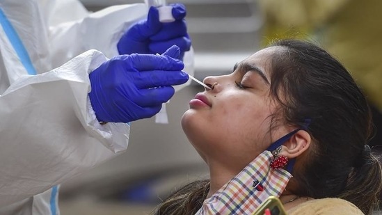 A health worker collects a swab sample of a passenger for a Covid-19 test. (PTI Photo)