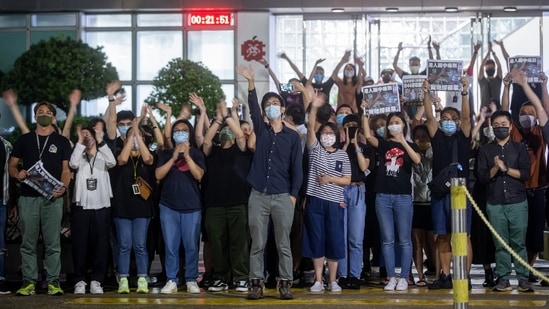 Apple Daily staff members wave outside the headquarters of the newspaper and its publisher Next Digital Ltd., in Hong Kong on June 24. "Thank you to all readers, subscribers, ad clients and Hong Kongers for 26 years of immense love and support," the paper said in an online article. "Here we say good-bye, take care of yourselves." (Paul Yeung / Bloomberg) Apple Daily staff members wave outside the headquarters of the newspaper and its publisher Next Digital Ltd., in Hong Kong on June 24. "Thank you to all readers, subscribers, ad clients and Hong Kongers for 26 years of immense love and support," the paper said in an online article. "Here we say good-bye, take care of yourselves." (Paul Yeung / Bloomberg)
