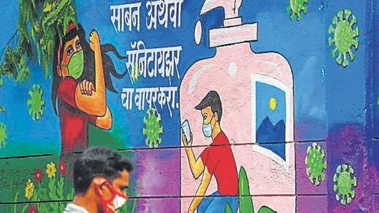 A pedestrian walks past a wall mural representing awareness measures against the Covid-19 coronavirus, in Navi Mumbai. (File photo)