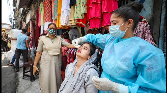 A health worker collects a nasal sample from a woman for Covid-19 testing at a market in Jammu. (File photo)