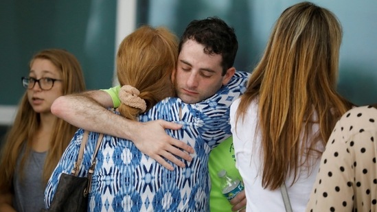 People embrace at the Surfside Community Center where authorities are taking residents and relatives from a partially collapsed building in Surfside near Miami Beach, on June 24. Displaced residents are trying to figure out where they can now live, whether it's with relatives or in hotels which have offered rooms. Others are waiting grimly for news of their loved ones.(Marco Bello / Reuters)