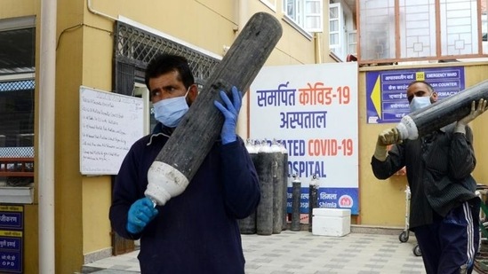 Health workers carrying oxygen cylinders from a store in a hospital in Shimla during second Covid-19 wave. (Deepak Sansta/HT file) Health workers carrying oxygen cylinders from a store in a hospital in Shimla during second Covid-19 wave. (Deepak Sansta/HT file)
