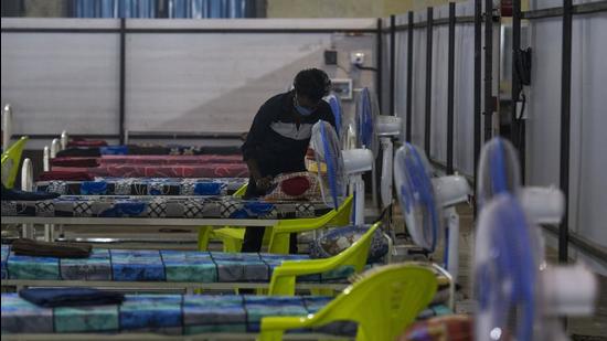 A Volunteer prepares beds inside a newly-built hall for Covid-19 cases to be inaugurated at NESCO, Goregaon in Mumbai. (HT file photo)