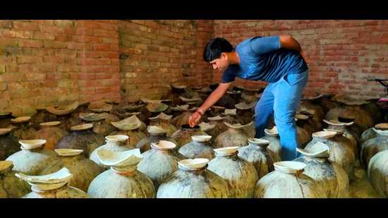 Rajkishore checking the vinegar getting ready in earthen pots in his village home. (HT photo) Rajkishore checking the vinegar getting ready in earthen pots in his village home. (HT photo)