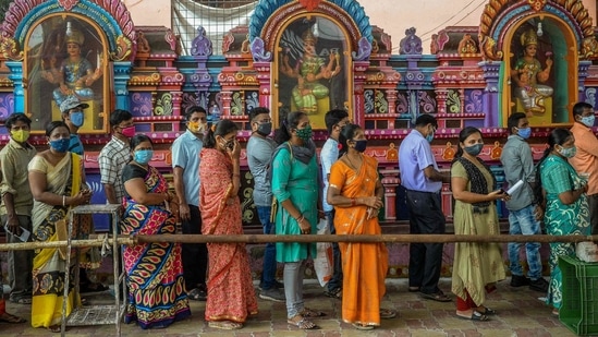People in a queue to get inoculated with a Covid-19 vaccine at a camp organised outside a temple in Hyderabad on June 25. India's single day Covid-19 case rise dropped to below 50,000 on June 26 as 48,698 fresh cases of the coronavirus disease were logged. pushing the total infection tally to 30,183,143, according to the Union health ministry dashboard at 8am.(Noah Seelam / AFP)