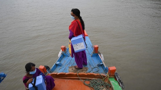 Health workers carrying Covid-19 vaccine boxes, travel aboard a ferry after a vaccination drive at Sundarbans islands of South 24 Parganas district, West Bengal on June 25. The Union Government has said that the new variant is very limited and it cannot be said that it is showing an upward trend.(Dibyangshu Sarkar / AFP)