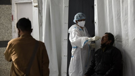 A health worker collects a swab sample from a traveller to test for Covid-19 infection. (HT Photo) A health worker collects a swab sample from a traveller to test for Covid-19 infection. (HT Photo)
