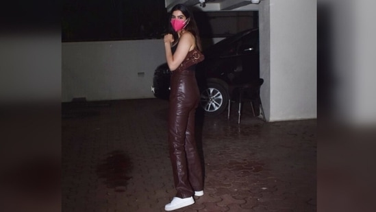 Janhvi Kapoor's youngest sister also wore a pink face mask to round off her glam leather look. She left her locks open in a middle parting.(Varinder Chawla)