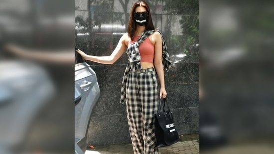 The check print high waist pants featured a straight fit and belt loops on the waistline. Kriti brought the ensemble together with chunky white lace-up sneakers, a Saint Laurent Rive Gauche black tote bag and sunglasses. (Varinder Chawla) The check print high waist pants featured a straight fit and belt loops on the waistline. Kriti brought the ensemble together with chunky white lace-up sneakers, a Saint Laurent Rive Gauche black tote bag and sunglasses. (Varinder Chawla)