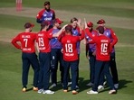 England's David Willey and Moeen Ali celebrate with teammates.