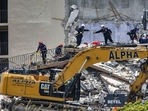 A South Florida Urban Search and Rescue team looks for survivors at the 12-story oceanfront condo that partially collapsed early Thursday.(AP) A South Florida Urban Search and Rescue team looks for survivors at the 12-story oceanfront condo that partially collapsed early Thursday.(AP)
