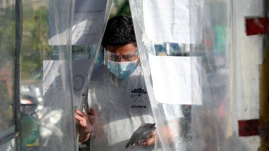 A man wearing a face mask and a face shield as protection against Covid-19 enters a disinfection booth at a community quarantine checkpoint in Philippines.(Reuters file photo)