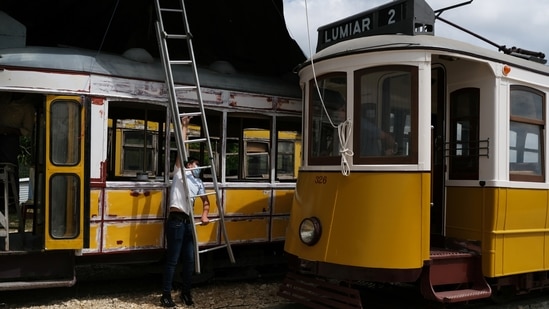 Paulo Marques rides a tram from his collection as his son helps to clear the way, in Carregado, Portugal, June 22, 2021.  (REUTERS)