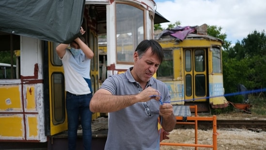 Paulo Marques and his son stand near a tram from his collection, in Carregado, Portugal, June 22, 2021.  (REUTERS)