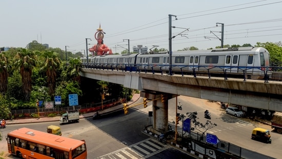 New Delhi: A train runs on its tracks in the backdrop of a Hanuman temple after resumption of the Delhi Metro services in a graded manner, in New Delhi, Monday, June 7, 2021. (PTI) New Delhi: A train runs on its tracks in the backdrop of a Hanuman temple after resumption of the Delhi Metro services in a graded manner, in New Delhi, Monday, June 7, 2021. (PTI)