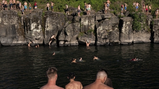 Cliff divers line up along the Clackamas River at High Rocks Park at on June 27 in Portland, Oregon. Because of climate change, record-setting temperatures are becoming more frequent. Globally, the decade to 2019 was the hottest recorded, and the five hottest years have all occurred within the last five years, AFP reported.(Nathan Howard / Getty Images / AFP)