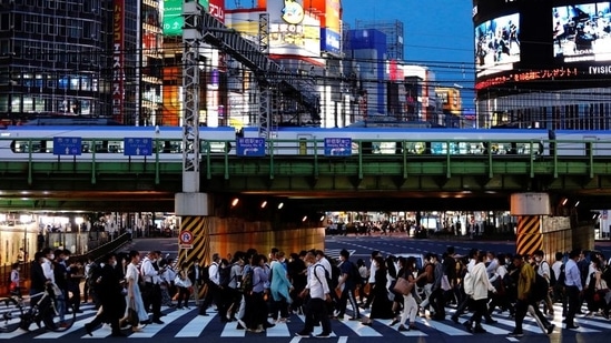 People crossing a road in Shinjuku, Tokyo on June 3. Half a century earlier, in 1964, the Games heralded a new era of modernity for a city risen from the ashes of a war that had ended fewer than two decades before. Their symbol was the sleek high-speed bullet trains that began running just days before the opening ceremony, Reuters reported.(Androniki Christodoulou / REUTERS)