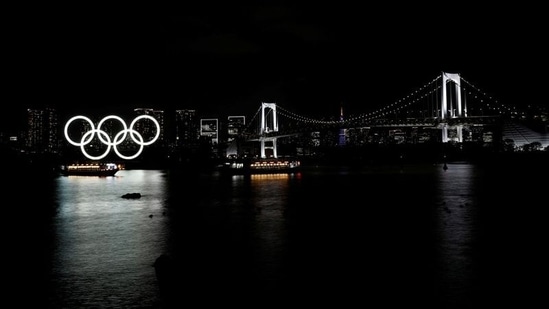 Boats sail past the giant Olympic rings and the Rainbow Bridge on the waterfront area of Odaiba Marine Park in Tokyo on April 2. The pandemic isn't over yet. There are still strong calls to cancel or postpone the Olympics. A quasi-state of emergency remains in place just a month before the Games begin.(Kim Kyung-Hoon / REUTERS)