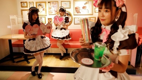 Cast members Hitomi, Kashima and Chia-can, greet guests at 'At-home Cafe', a maid cafe that is a subset of cosplay restaurants, in Akihabara district, Tokyo on June 8. Life has gone on even as the city lurches in and out of soft lockdowns. Streets have emptied on some nights, filled on others with people and the hubbub of life.(Issei Kato / REUTERS)