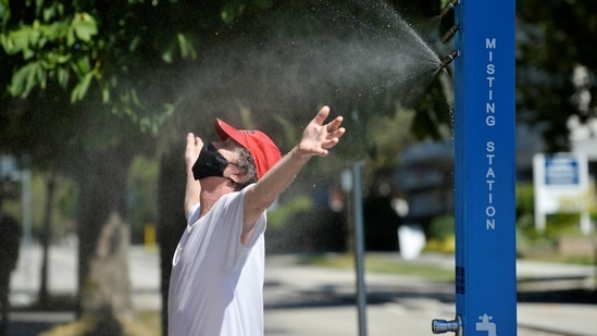 A man cools off at a misting station during the scorching weather of a heatwave in Vancouver, British Columbia, Canada on June 27. The current heat wave over the Northwest started with flooding rains across China on June 23, said Masters. That fed energy into the jet stream across the North Pacific, making it stronger than usual and setting off a chain reaction of weather patterns that led to the high pressure ridge building over western North America and driving temperatures up in the U.S. and Canada.(Jennifer Gauthier / REUTERS)