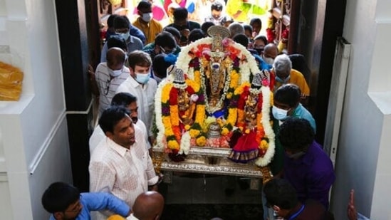 Sri Venkateswara Temple devotees and volunteers carry a deity back into the temple during Maha Kumbhabhishekam.(AP) Sri Venkateswara Temple devotees and volunteers carry a deity back into the temple during Maha Kumbhabhishekam.(AP)