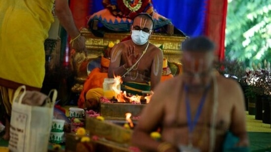 Priest Sri Bharadan Venkata Desikan makes an offering to the deities through a fire altar during the Maha Kumbhabhishekam.(AP) Priest Sri Bharadan Venkata Desikan makes an offering to the deities through a fire altar during the Maha Kumbhabhishekam.(AP)