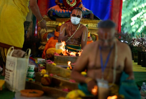 O Sacerdote Sri Bharadan Venkata Desikan faz uma oferenda às divindades através de um altar de fogo durante o Maha Kumbhabhishekam. (AP)