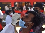 A health worker collects swab samples for Covid-19 test of passengers arriving from outstation trains, at Dadar station in Mumbai on Tuesday.