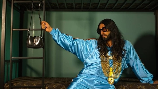 Ranveer shared images of himself wearing a shiny jersey sweatshirt with web in light blue. The sweatshirt had the Gucci vintage logo label, a high neck and metal buttons, with the green and red ribbon detailing synonymous with Gucci stitched across the sleeves and shoulders.(Instagram)