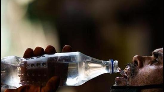 A labourer quenches his thirst with water from a bottle on a street amid rising temperatures in New Delhi. (File photo)
