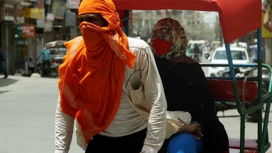 A rickshaw puller covers his face from the heatwave as temperature touches 44 degrees, in New Delhi on Wednesday. (ANI Photo)