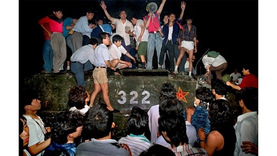 Civilians with rocks stand on a military armored vehicle near Chang'an Boulevard in Beijing as violence escalated between pro-democracy protesters and Chinese troops, leaving hundreds dead overnight on June 4, 1989.(Jeff Widener / AP)