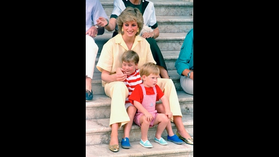 Britain's Princess Diana of Wales smiles as she sits with her sons, Princes Harry, foreground, and William, on the steps of the Royal Palace on the island of Mallorca, Spain. Gracing monotone style she adds a touch of glitter with her accessories. (AP) Britain's Princess Diana of Wales smiles as she sits with her sons, Princes Harry, foreground, and William, on the steps of the Royal Palace on the island of Mallorca, Spain. Gracing monotone style she adds a touch of glitter with her accessories. (AP)
