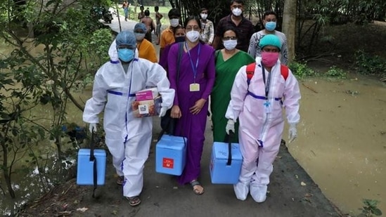 Healthcare workers carry Covishield doses to inoculate villagers during a door-to-door vaccination and testing drive in West Bengal.(Reuters Photo)