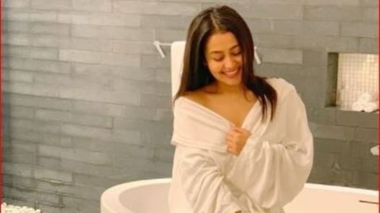 Neha Kakkar poses inside her bathroom, dressed in a bathrobe.