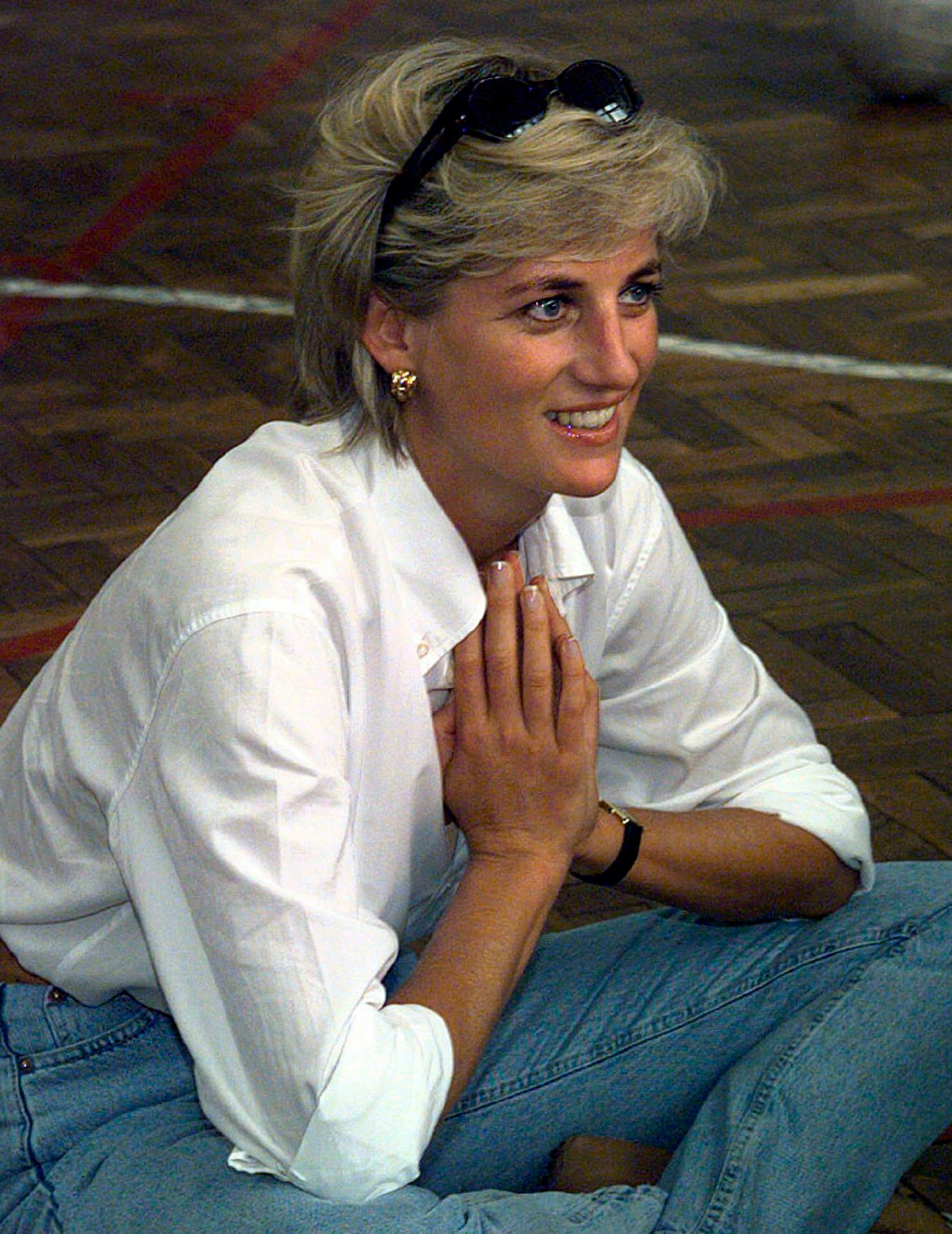 Princess of Wales, sits and talks to members of a Zenica volleyball team who have suffered injuries from mines, during her visit to Zenica, Bosnia. She believed in fashion classics for those informal minimalist looks. A white shirt with mommy jeans and gold earrings does the trick here. (AP) Princess of Wales, sits and talks to members of a Zenica volleyball team who have suffered injuries from mines, during her visit to Zenica, Bosnia. She believed in fashion classics for those informal minimalist looks. A white shirt with mommy jeans and gold earrings does the trick here. (AP)