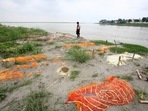 A municipal worker walks past shallow sand graves, some of which are suspected to be of people who died from Covid-19, on the Ganga riverbank in Phaphamau, on the outskirts of Prayagraj on June 25. Overnight, the country recorded 853 deaths on July 2, taking the toll past the 400,000 mark, according to data from health ministry.