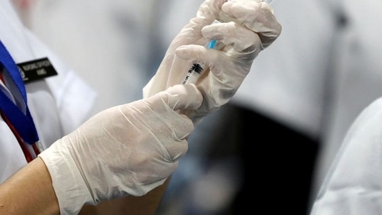 A healthcare worker fills a syringe with a dose of Covid-19 vaccine.(REUTERS)
