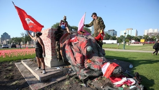 The statue of Queen Victoria was toppled outside the Manitoba provincial legislature to the cheer of many protesters and both the statue and pedestal were defaced with red paint hand marks.(Reuters)