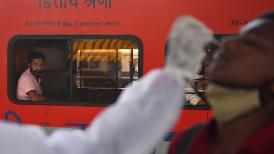 A BMC health worker testing people arriving on outstation trains at Dadar station in Mumbai on June 29. Experts believe India's reported deaths and infections are massive undercounts. They say an untold number of people died during the April and May surge outside of hospitals and before they could be tested for the virus. A model from the University of Washington’s Institute for Health Metrics and Evaluation estimates there have been more than 1.1 million Covid-19 deaths in India, AP reported.(Satish Bate / HT Photo)
