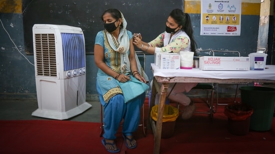 A health worker inoculating a woman in New Delhi on June 30. Last month, the head of India's Covid-19 task force told reporters that about 2 billion doses could be available by December under a roadmap that depends on India’s two main suppliers — Serum Institute of India and Bharat Biotech — ramping up production and five other potential vaccines being made available, AP reported.(Sanchit Khanna / HT Photo)